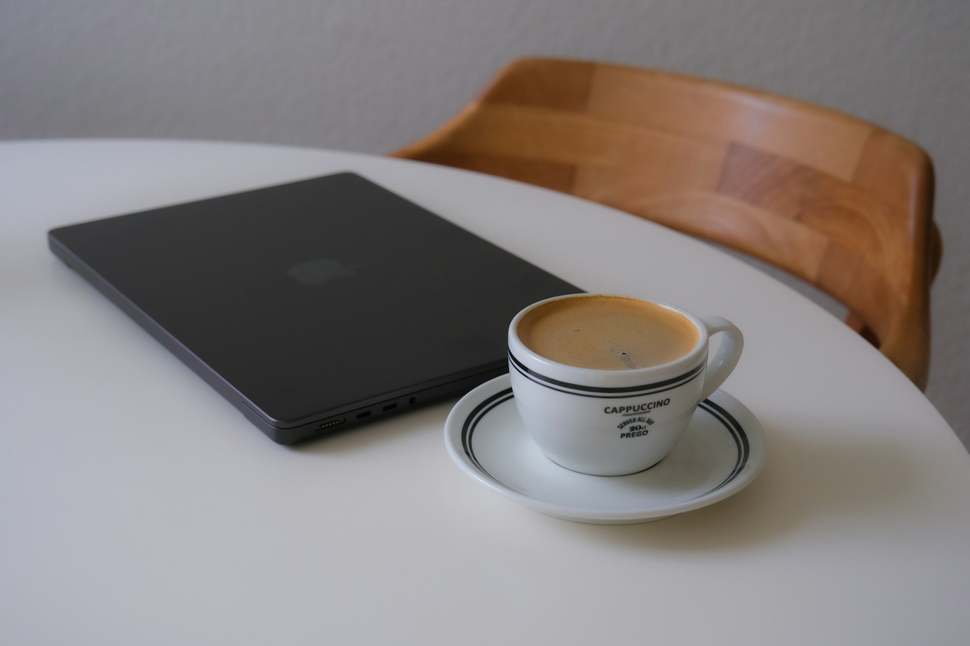 Laptop and coffee cup on a white table